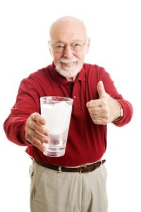 Older man drinking glass of water and staying hydrated